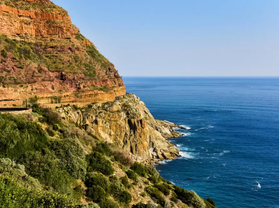 Scenic view of rugged cliffs overlooking the azure waters along Chapman's Peak Drive in South Africa.