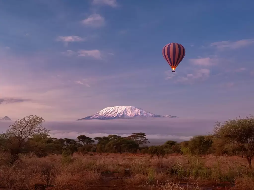 Hot air balloon over Kilimanjaro; a luxury African safari planned by the best travel agents. 