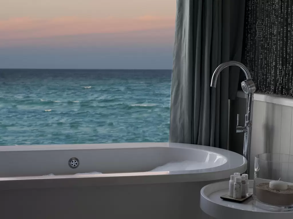 An ocean-facing bathtub in Mozambique’s Ponta Mamoli luxury beach resort suite at sunset.