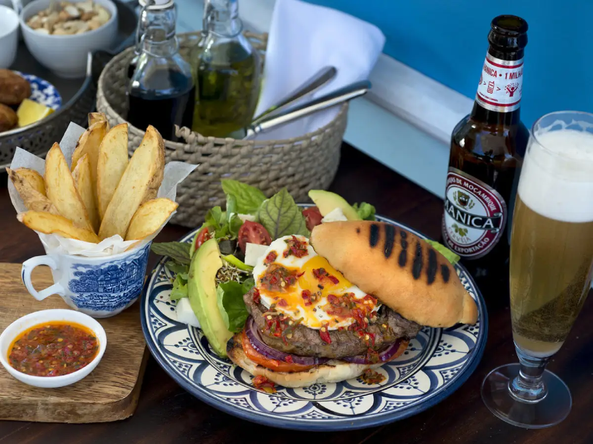 A Gourmet Mozambique meal with burger, fries, and local beer at &Beyond Benguerra Island.